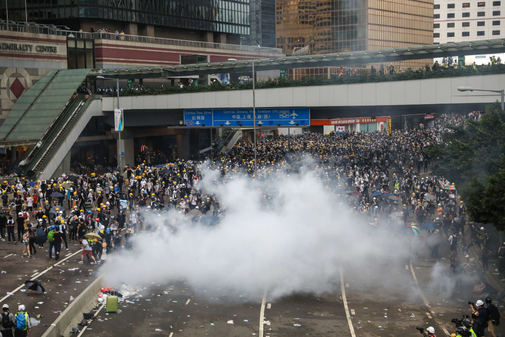 Protesters react after police fired tear gas during a rally against a controversial extradition law proposal outside the government headquarters in Hong Kong on June 12, 2019.