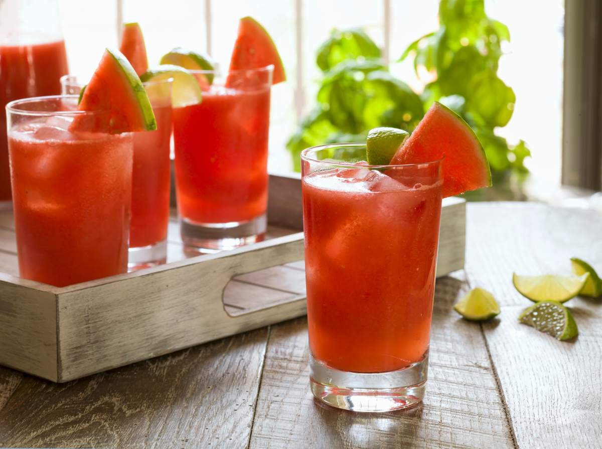 Watermelon cocktails on a rustic wooden tray.
