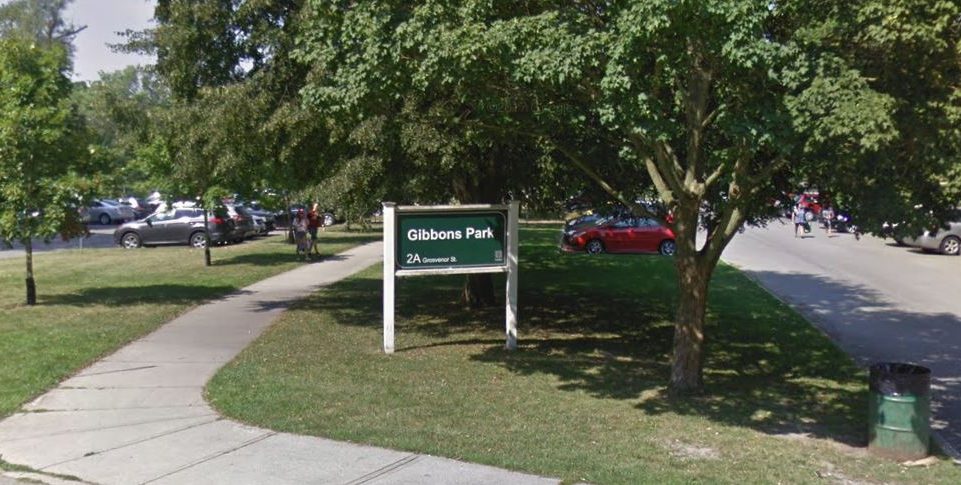 A photo of a parking lot around a sign for a park.