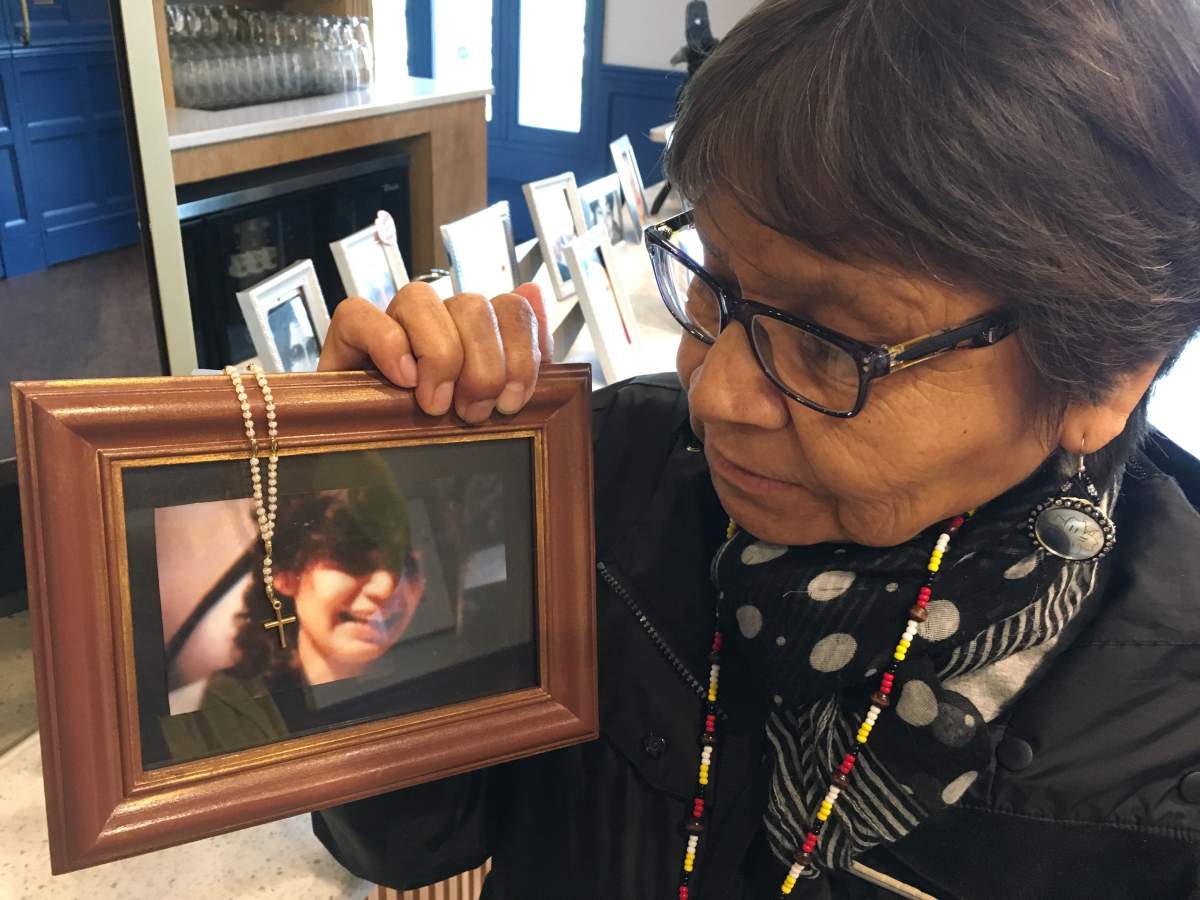 Isabel Fontaine holding a photo of her sister Sharon Abraham who went missing in 2000.