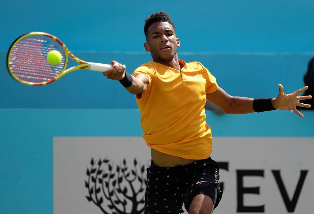 Felix Auger-Aliassime of Canada plays a return to Stefanos Tsitsipas of Greece during their quarterfinal singles match at the Queens Club tennis tournament in London, Friday, June 21, 2019.