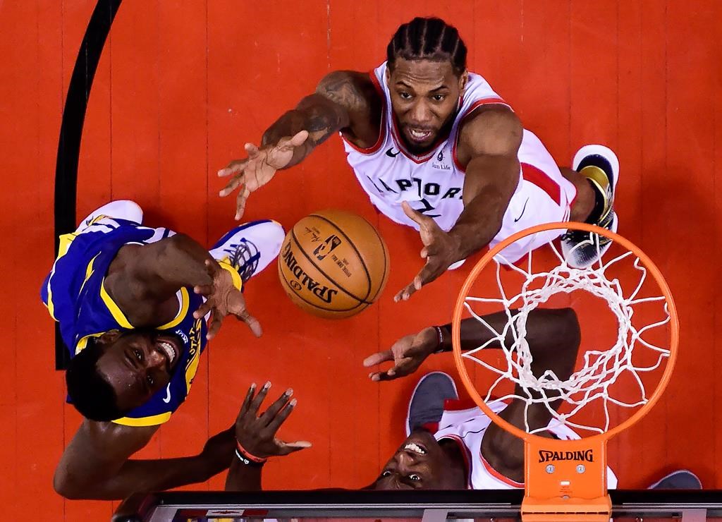 Toronto Raptors forward Pascal Siakam (43) and Toronto Raptors forward Kawhi Leonard (2) eye the ball against Golden State Warriors forward Draymond Green (23) during the second half of Game 2 of the NBA Finals in Toronto on Sunday, June 2, 2019.
