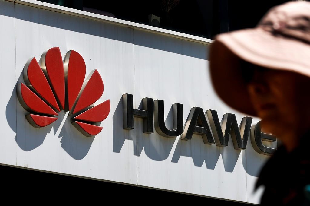 FILE - In this May 29, 2019, file photo, a woman walks by a Huawei retail store in Beijing. A federal jury in Texas rejected Wednesday, June 26, 2019, claims by Chinese telecom-equipment maker Huawei Technologies that Silicon Valley start-up CNEX stole its trade secrets. (AP Photo/Andy Wong, File).