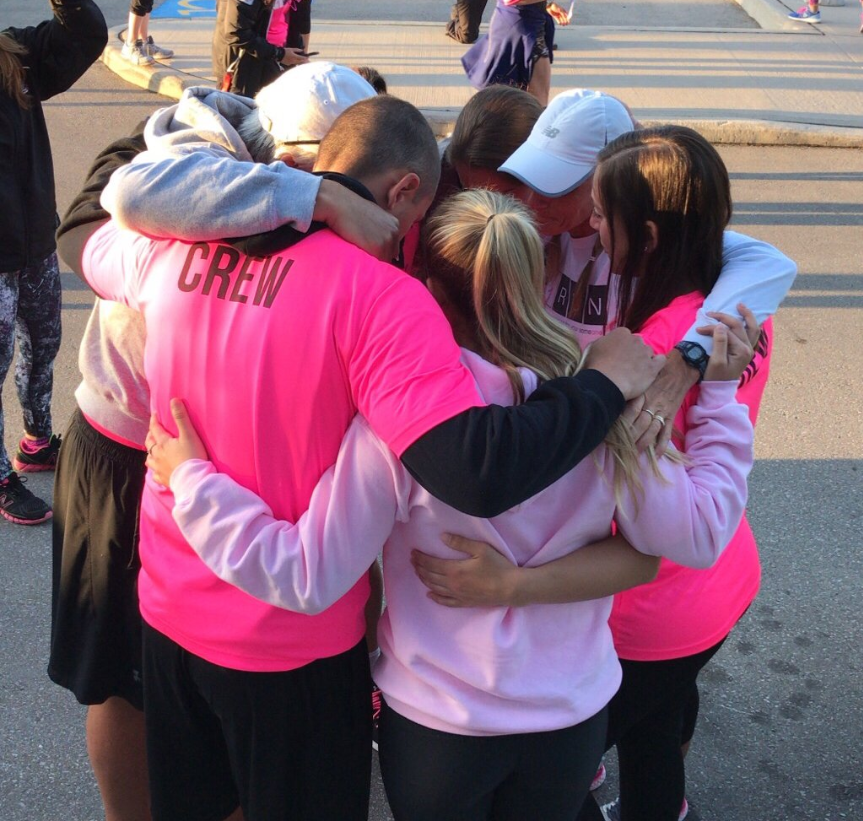 Theresa Carriere (top right) has a group hug with some of her team before hitting the road for the fifth 100 kilometre ONERUN jounrey.