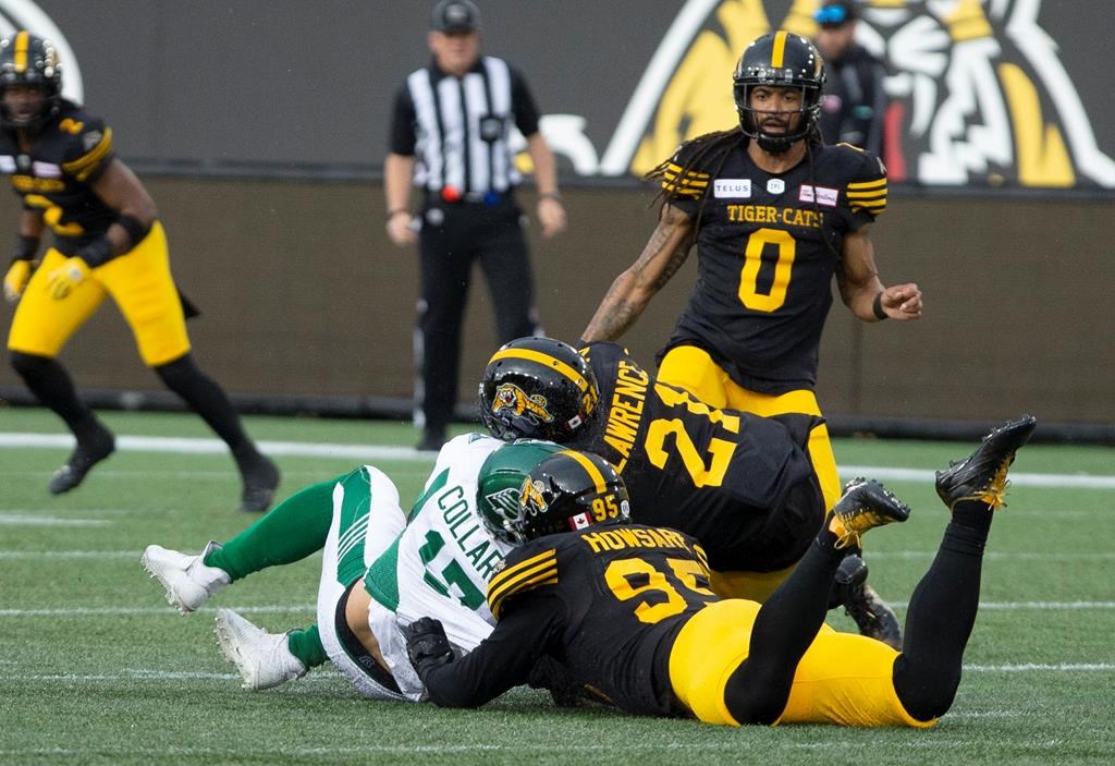 Saskatchewan Roughriders quarterback Zach Collar is hit late by Hamilton Tiger-Cats' Simoni Lawrence after Collaros was downed by Tiger-Cats' Julian Howsare during first-half CFL football game action in Hamilton on Thursday, June 13, 2019.