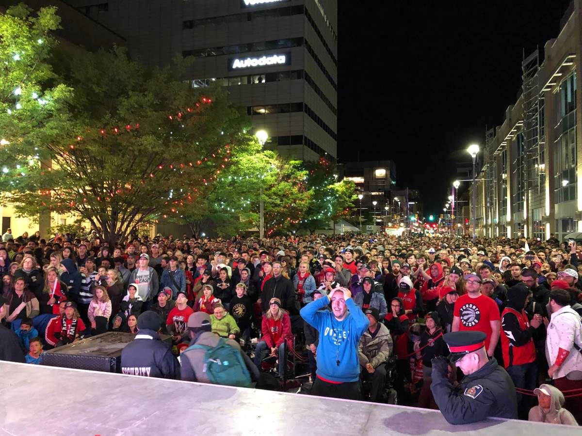 Londoners gathered in Dundas Place look on as the Toronto Raptors fall 106-105 to the Golden State Warriors.