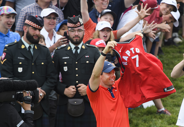 Rory McIlroy of Northern Ireland holds up a Toronto Raptors jersey moments after winning the 2019 Canadian Open golf championship in Ancaster, Ont., on Sunday. 