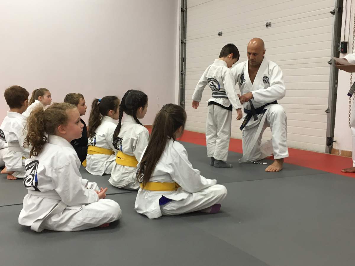 Royce Gracie gives a young student his new belt in Halifax.