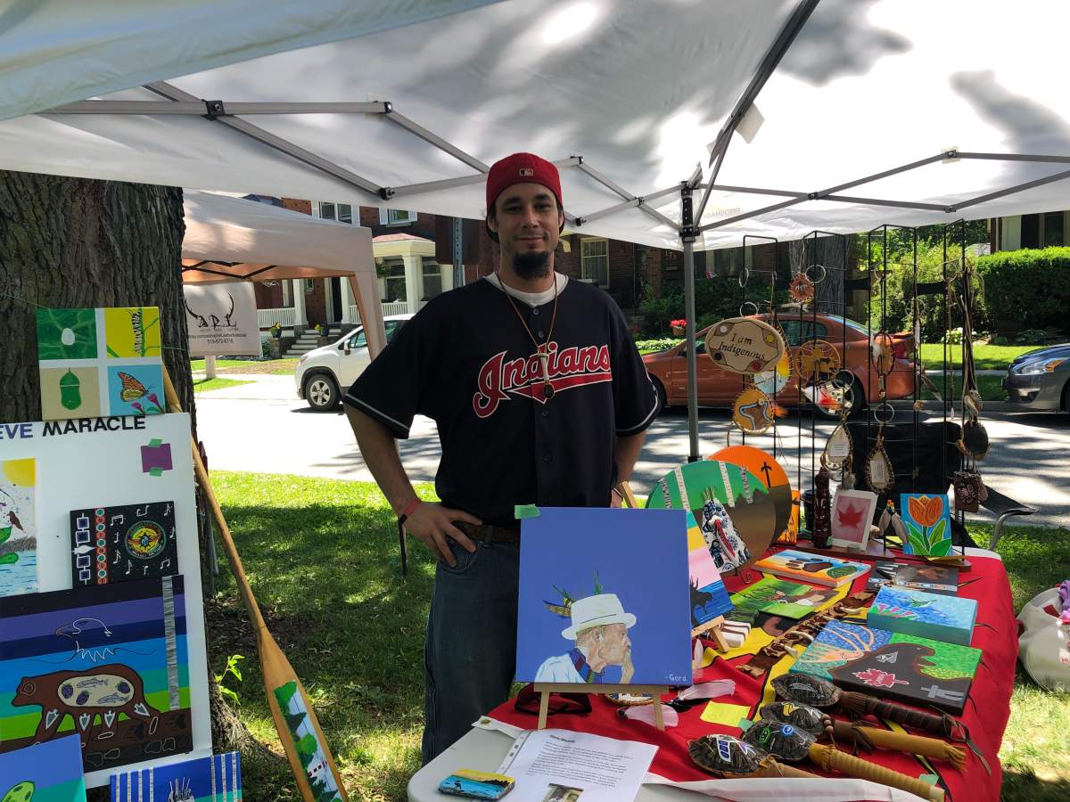 Steve Maracle poses with a number of his paintings during Indigenous Solidarity Day
