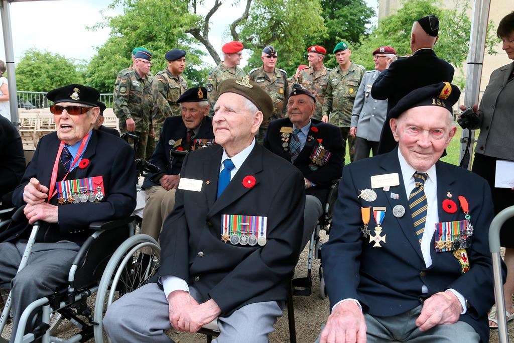 Canadian veterans Al Roy, centre, and Hugh Patterson, right, attend a French-Canadian ceremony to commemorate the Poche de Falaise battle in Chambois, Normandy, Tuesday, June 4, 2019. 