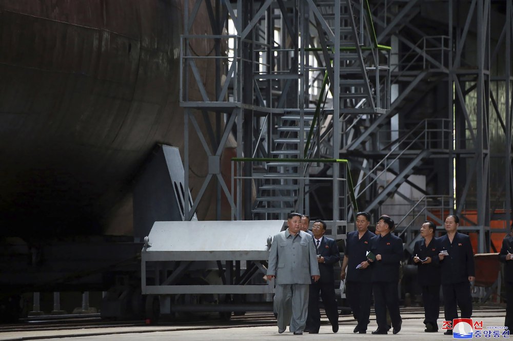 In this undated photo provided on Tuesday, July 23, 2019, by the North Korean government, North Korean leader Kim Jong Un, left, inspects a newly built submarine to be deployed soon, at an unknown location in North Korea.