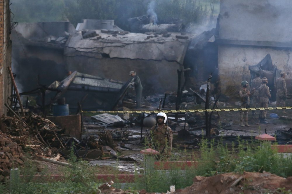 Pakistan army officials examine the site of a plane crash in Rawalpindi, Pakistan, Tuesday, July 30, 2019. A small Pakistani military plane crashed into a residential area near the garrison city of Rawalpindi before dawn, killing some people, officials said. 