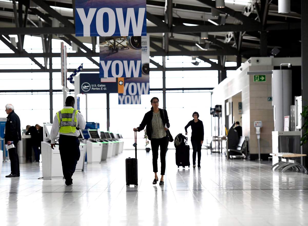 Passengers walk in the departures terminal at the Ottawa International Airport on Monday, May 28, 2018. 