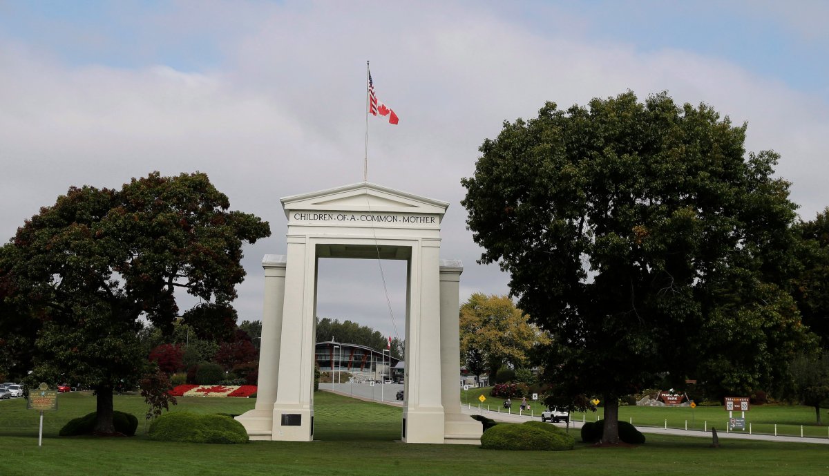 In this Sept. 26, 2018 photo, U.S. and Canadian flags fly on the Peace Arch monument at the U.S.-Canadian border near Blaine, Wash., and Surrey, British Columbia.
