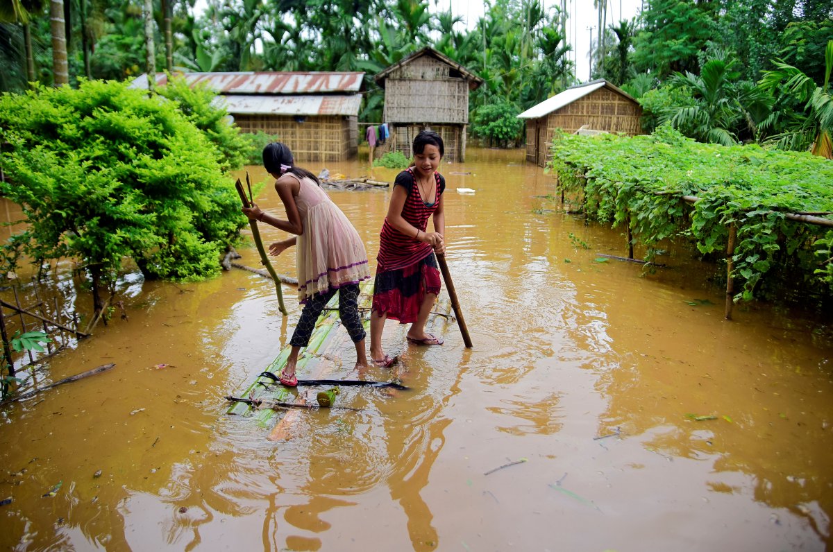 Girls row a makeshift raft past submerged houses at a flood-affected village in Karbi Anglong district, in the northeastern state of Assam, India, July 11, 2019. 