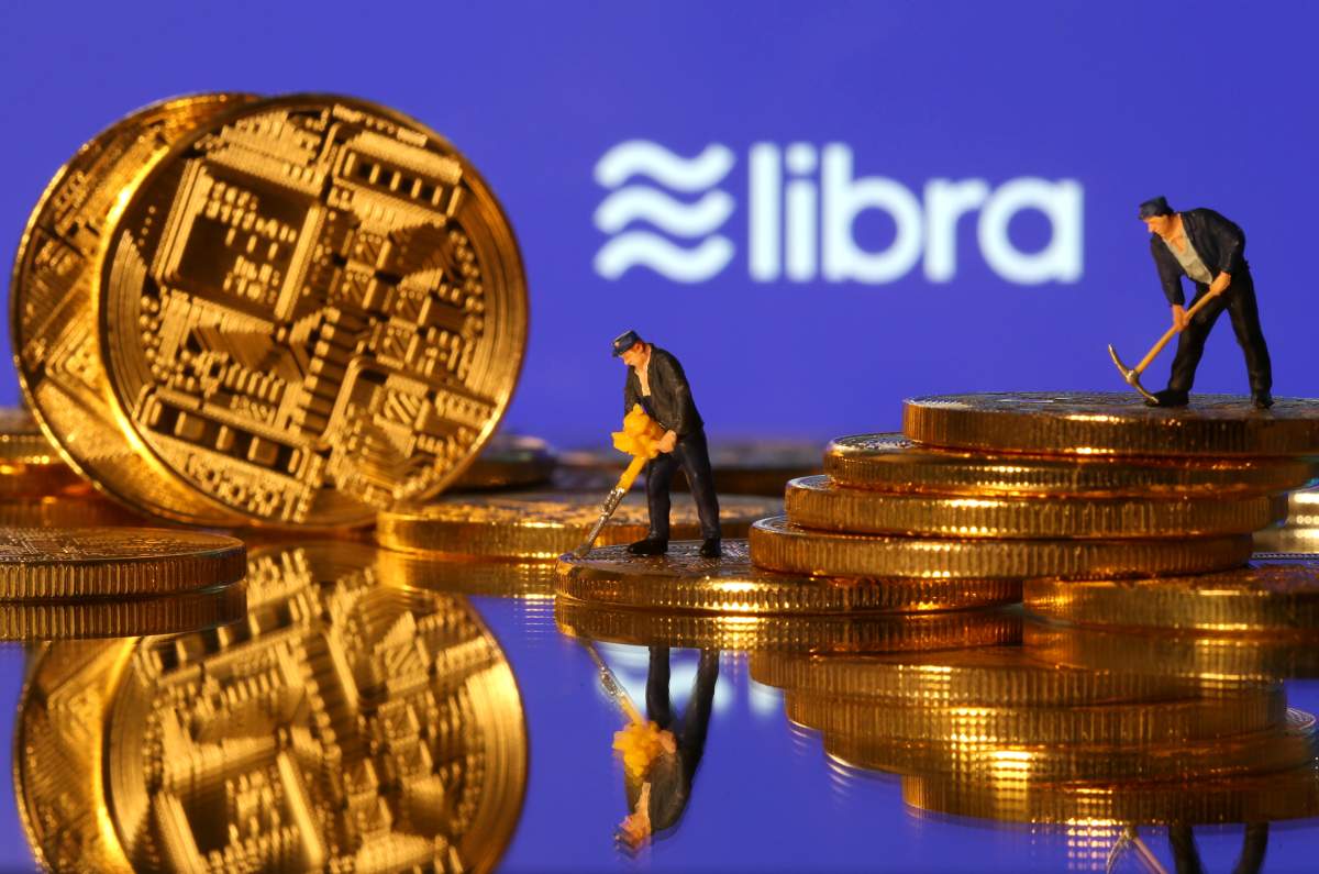 Small toy figures are seen on representations of virtual currency in front of the Libra logo in this illustration picture, June 21, 2019. 