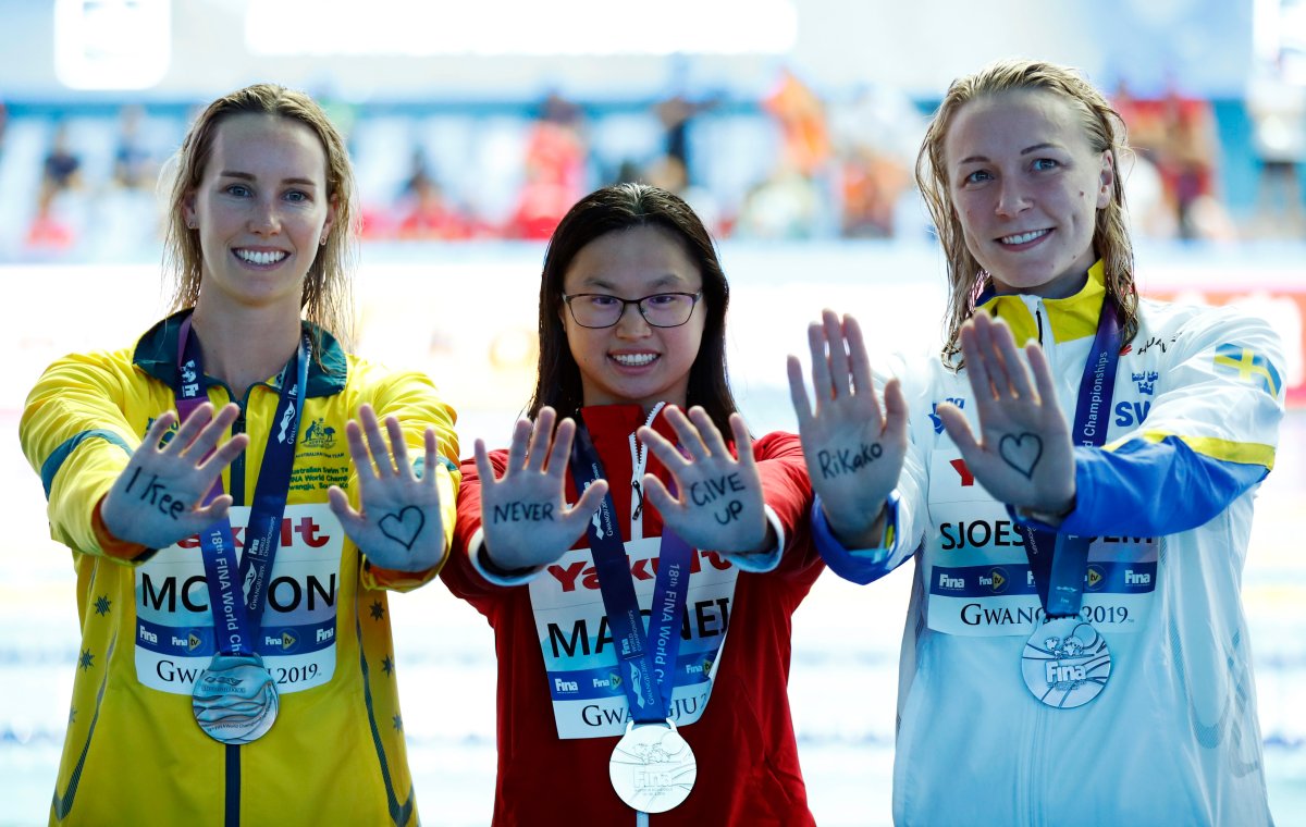Gold medallist Margaret MacNeil of Canada, silver medallist Sarah Sjoestroem of Sweden and bronze medallist Emma McKeon of Australia pose. 