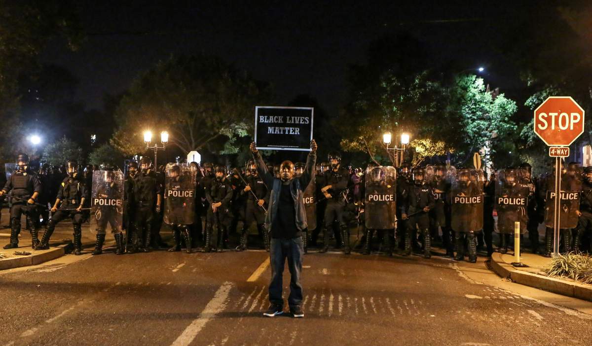 A Black Lives Matter protester stands in front of St. Louis Police Department officers equipped with riot gear after the not guilty verdict in the murder trial of Jason Stockley, a former St. Louis police officer, charged with the 2011 shooting of  Anthony Lamar Smith, who was black, in St. Louis, Missouri, U.S., September 15, 2017.  