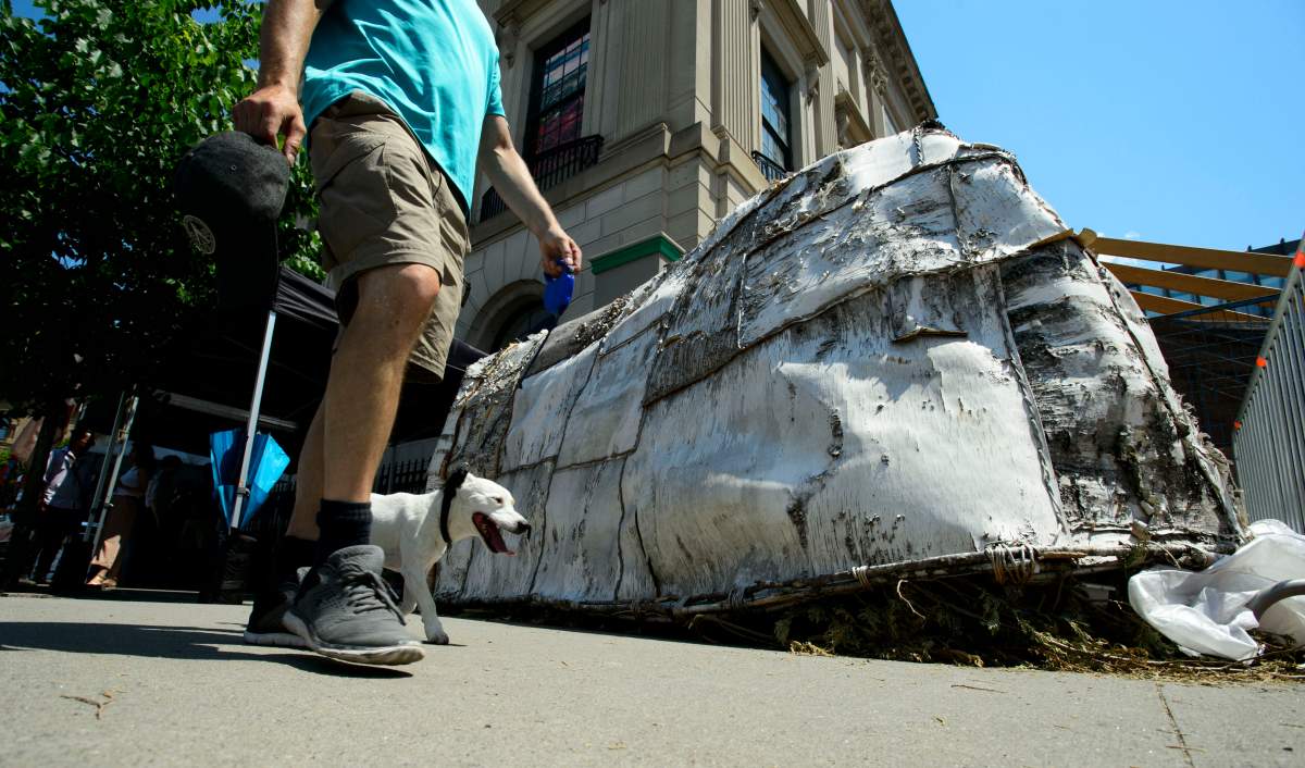 A man and his dog walk past a wigwam where Verna Polson, grand chief of the Algonquin Anishinabeg Nation Tribal Council, is hunger striking due to a lack of consultations regarding the former US Embassy building which was dedicated to Indigenous people. 
