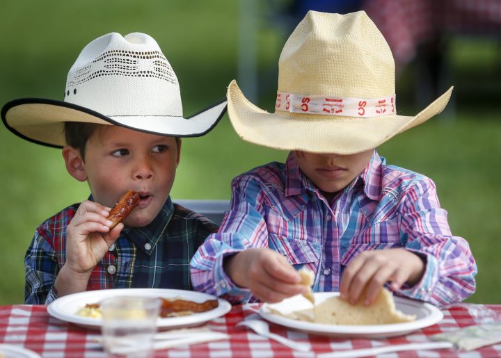 Young cowpokes enjoy a Stampede breakfast in Calgary, Saturday, July 6, 2019. 