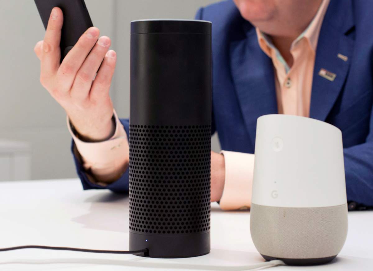 FILE - In this June 14, 2018, photo, an Amazon Echo, center, and a Google Home, right, are displayed in New York.