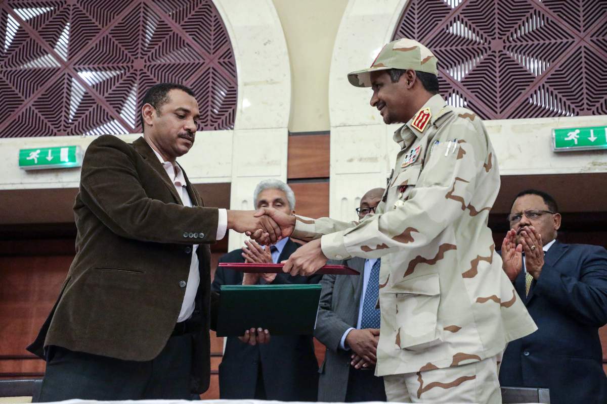 Gen. Mohammed Hamdan Dagalo, right, and Sudan's pro-democracy movement leader Ahmad al-Rabiah shake hands after signing a power sharing document in Khartoum, Sudan, Wednesday, July 17, 2019. The two sides are still at work on a more contentious constitutional agreement that would specify the division of powers. 