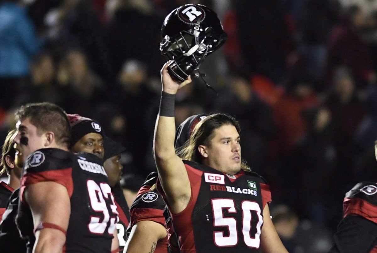 Ottawa Redblacks long snapper Louis-Philippe Bourassa (50) holds up his helmet as the team celebrates winning against the Hamilton Tiger-Cats following second half CFL action in Ottawa on Oct. 27, 2017.