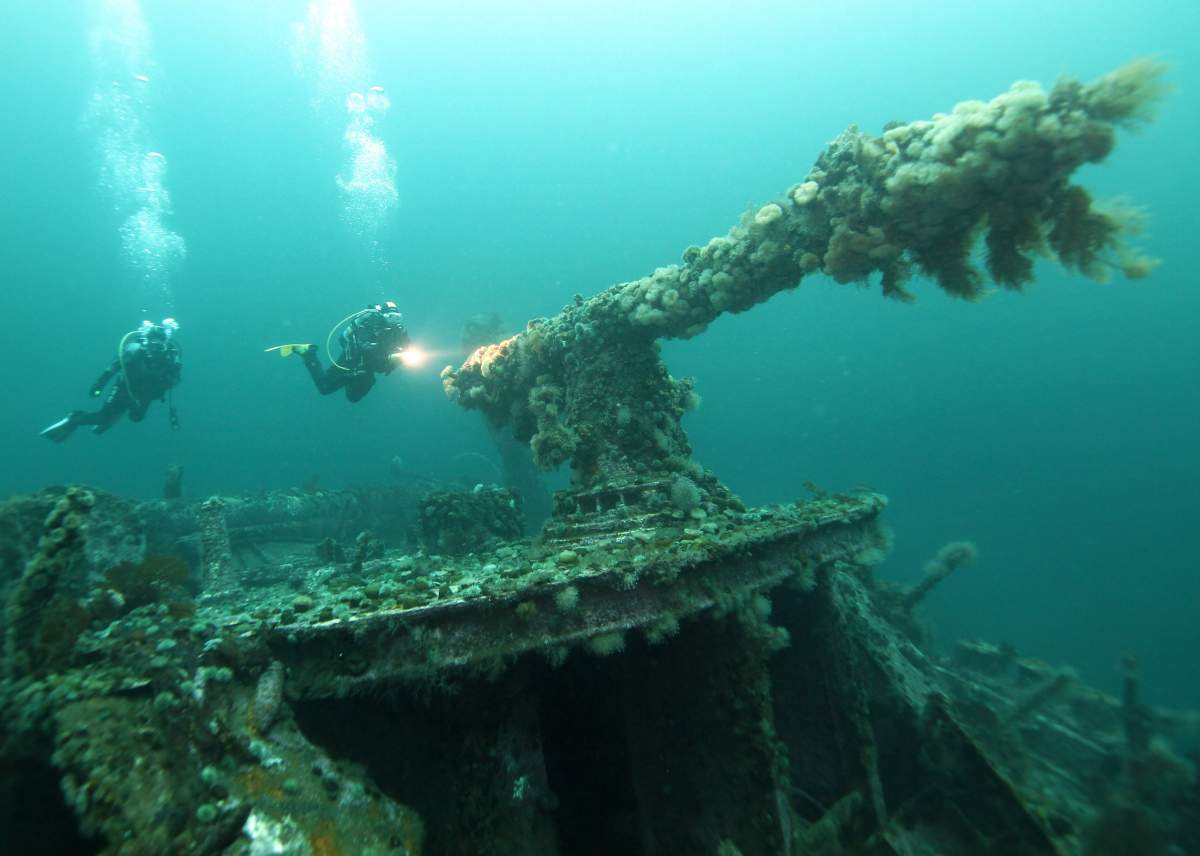 Divers explore the gun on the deck of the SS Saganaga shipwreck off the coast of Bell Island, N.L., in an undated handout photo. 