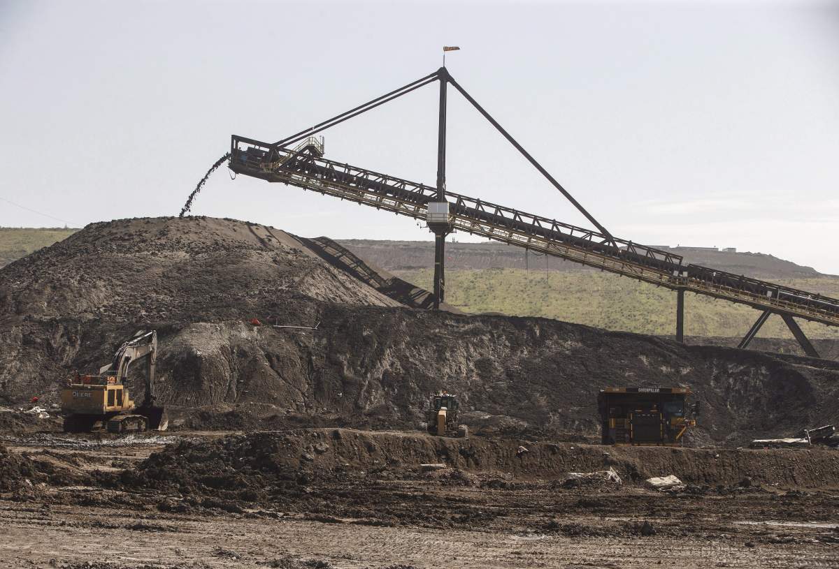 A hopper moves dirt in Suncor's Millennium mine in the oil sands in Fort McMurray Alta, on Monday June 13, 2017. The Canadian Energy Research Institute says it's getting cheaper to build an oilsands project but the pace of growth over the next 20 years is expected to be slower than previously forecast. 
