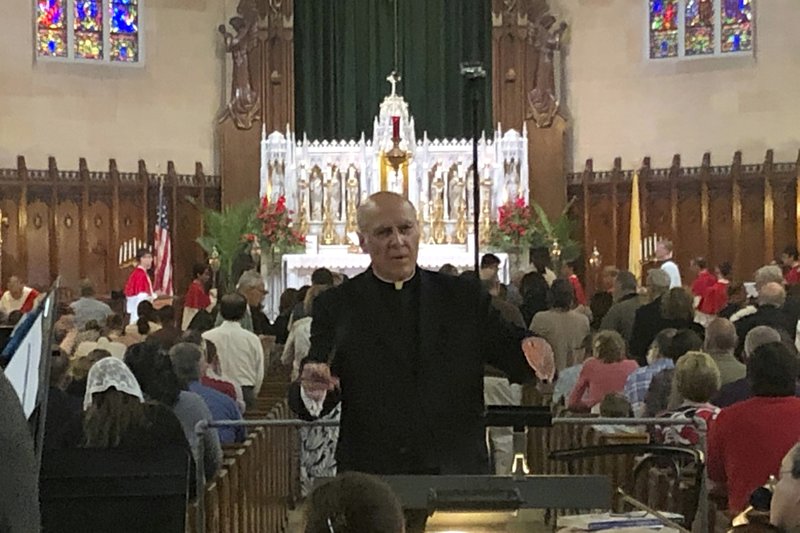 In this June 9, 2019 photo, Father Eduard Perrone conducts a choir during mass at Assumption of the Blessed Virgin March Parish in Detroit. The Roman Catholic Archdiocese of Detroit said Sunday, July 7 that it has removed Perrone from public ministry after receiving what it described as a "credible allegation" that he had abused a child decades ago. 