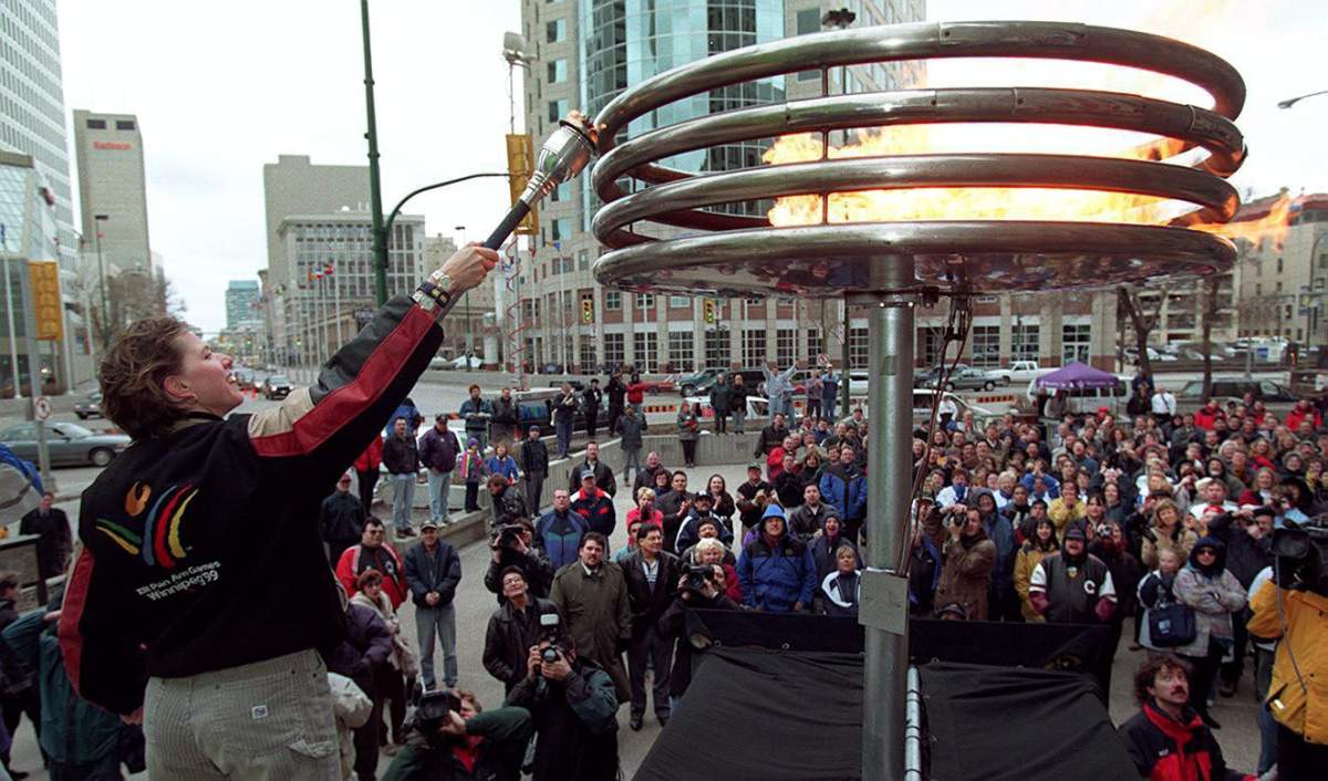 Canadian cyclist Tanya Dubnicoff lights the Pan Am Games flame in Winnipeg Thursday, April 15, 1999. Tuesday marks the 20th anniversary of the start of the games.