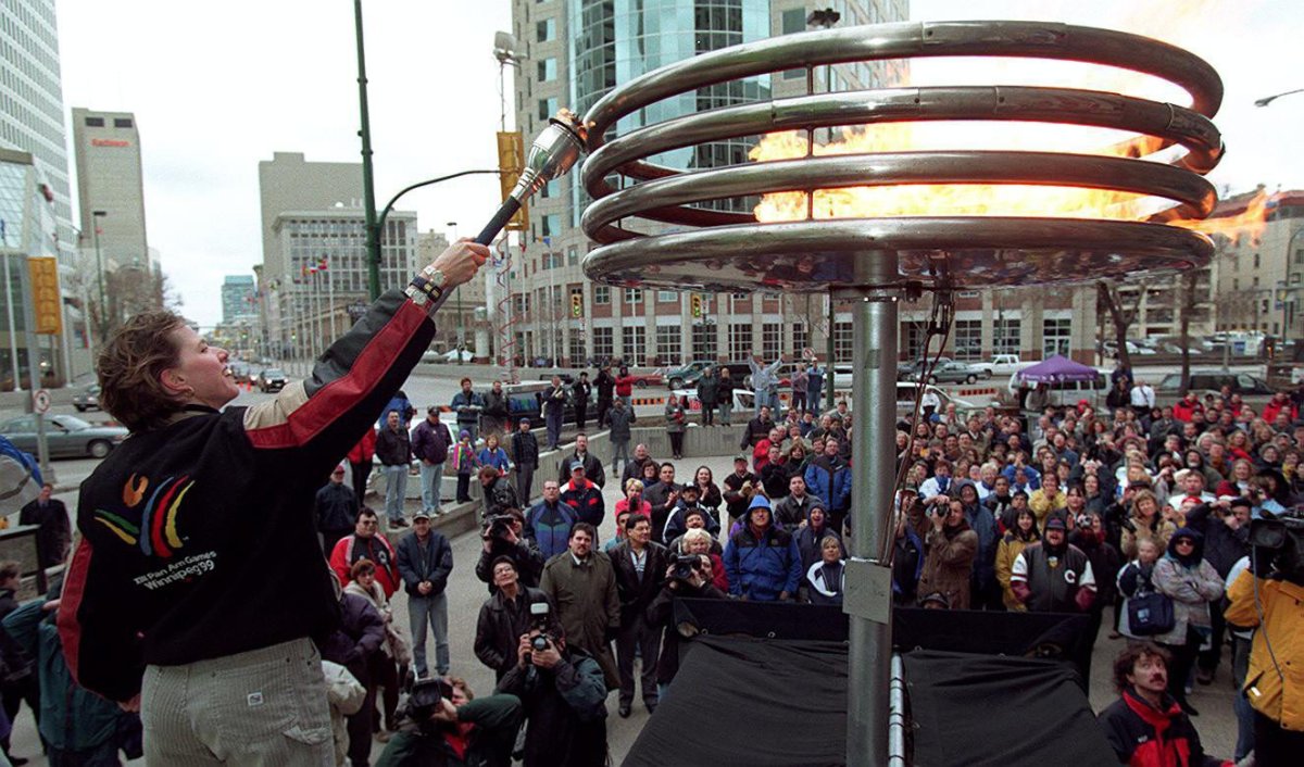 Canadian cyclist Tanya Dubnicoff lights the Pan Am Games flame in Winnipeg Thursday, April 15, 1999. Tuesday marks the 20th anniversary of the start of the games.