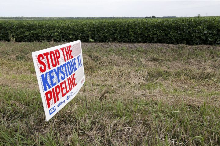 FILE - In this July 29, 2017 file photo, a sign reading: "Stop the Keystone XL Pipeline" sits in the proposed path of the Keystone XL pipeline, in Silver Creek, Neb.