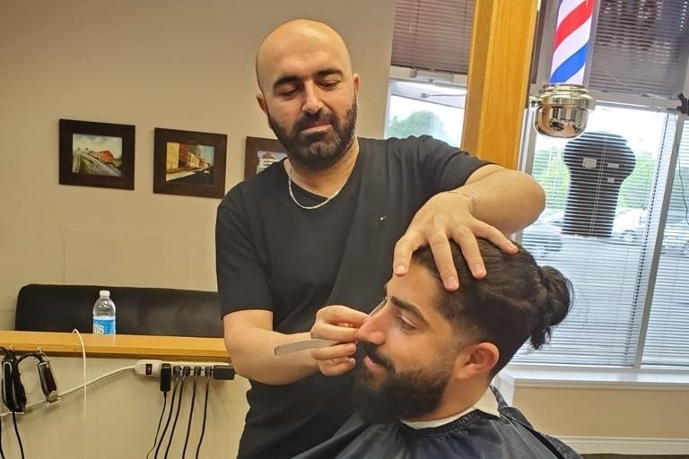 Jakar Al Isso with a customer at Barran Barber Shop.