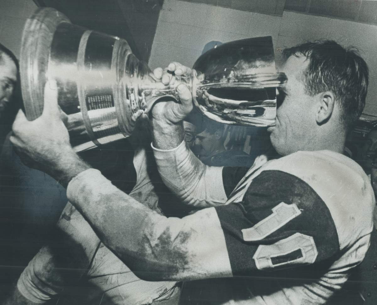 Victorious quarterback Bernie Faloney drinks deep from the Grey Cup.
