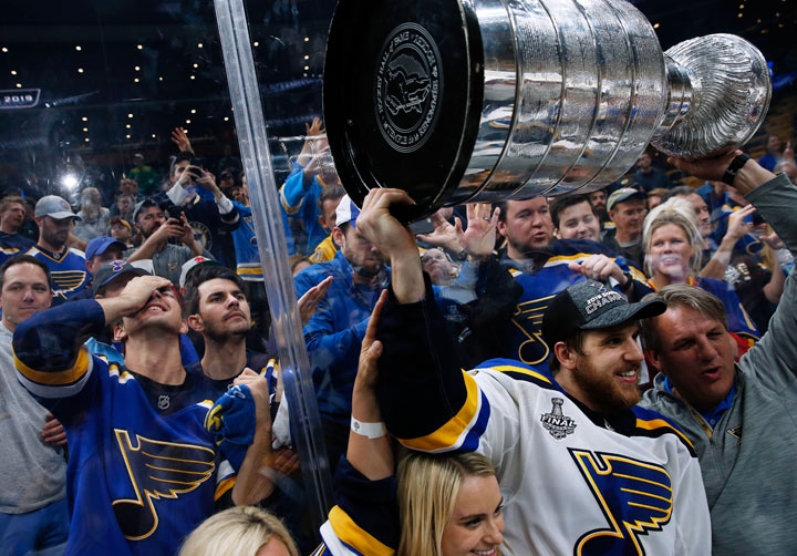 St. Louis Blues' Brayden Schenn carries the Stanley Cup as fans in the stands celebrate on June 12, 2019, in Boston, Mass.