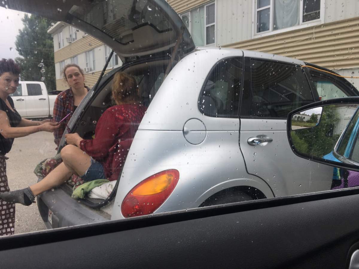 Three of the residents waiting outside of the fire-affected building in a car.