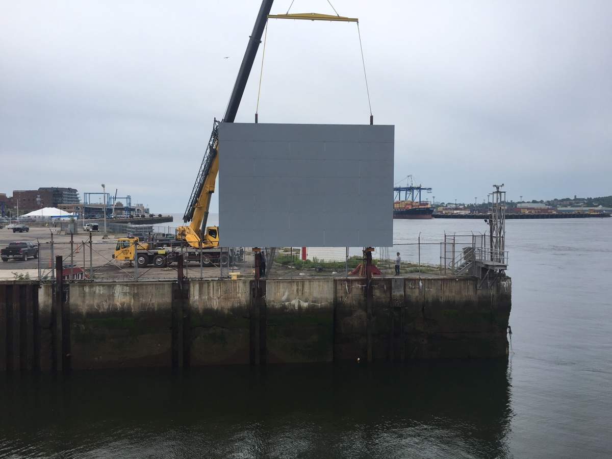 A 30-by-40-foot aluminum canvas is lowered into place at Market Slip in Saint John, N.B., on July 24, 2019.