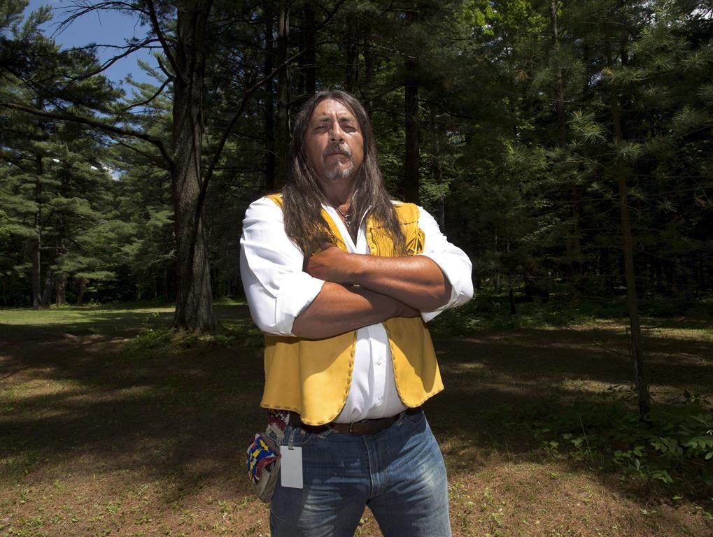 Kanesatake Grand Chief Serge Simon stands in The Pines on Thursday, June 18, 2015 in Kanesatake, Que., near the scene of the police raid 25 years ago that started the Oka Crisis.