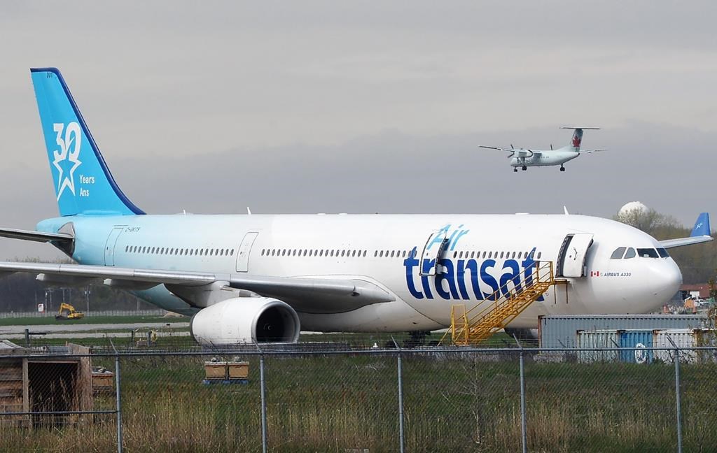 An Air Transat plane is seen as an Air Canada plane lands at Pierre Elliott Trudeau International Airport in Montreal on Thursday, May 16, 2019.