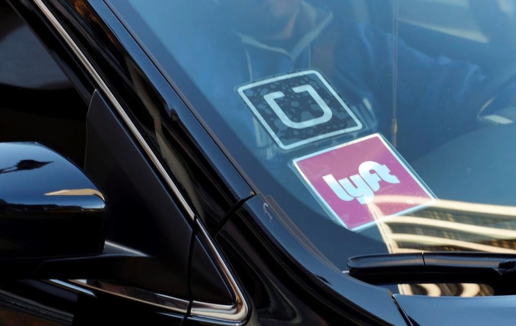 A ride share car displays Lyft and Uber stickers on its front windshield in downtown Los Angeles. So far in B.C. the two major players have only applied to provide service in the Lower Mainland region.
