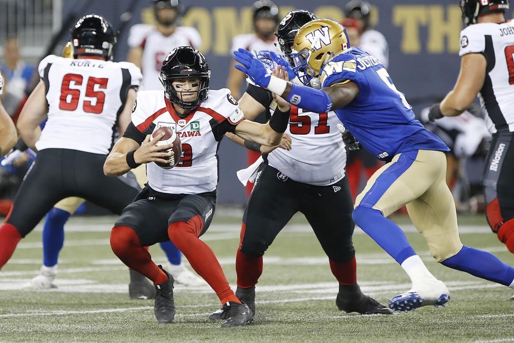 Ottawa Redblacks quarterback William Arndt (8) tries to avoid running into Winnipeg Blue Bombers' Willie Jefferson (5) during the second half of CFL action in Winnipeg, Friday, July 19, 2019. The Ottawa Redblacks are anxious to get back onto the field following a tough week last week in Winnipeg. THE CANADIAN PRESS/John Woods.