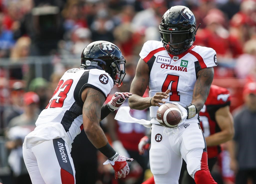 Ottawa Redblacks quarterback Dominique Davis, right, hands the ball off to Mossis Madu Jr., during first half CFL football action in Calgary, Saturday, June 15, 2019. The Redblacks have heard all about how good the Winnipeg Blue Bombers are supposed to be. But Ottawa is also undefeated and is looking forward to putting its record on the line against the Bombers on Friday.