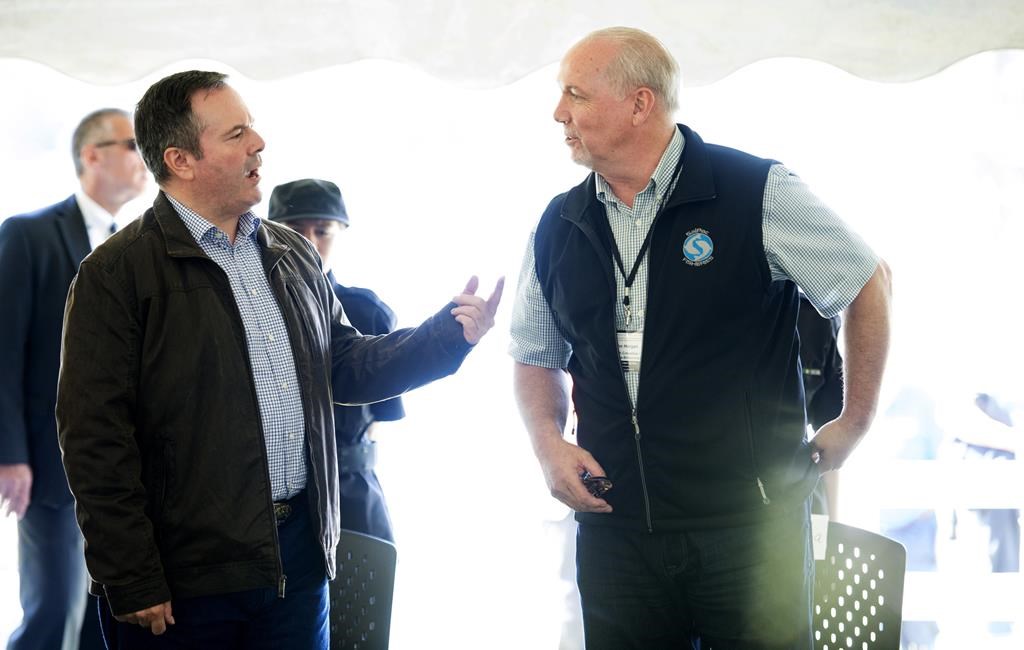 Alberta Premier Jason Kenney speaks with British Columbia Premier John Horgan during a meeting of Premiers and Indigenous Leaders in Big River, First Nation, Sask., Tuesday, July 9, 2019.