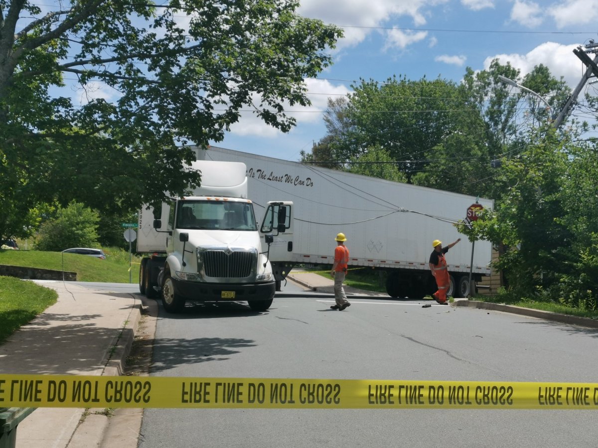 Nova Scotia Power crews work on freeing a semi truck from power lines on Pinehil Drive in Lower Sackville, N.S., on July 11, 2019. 