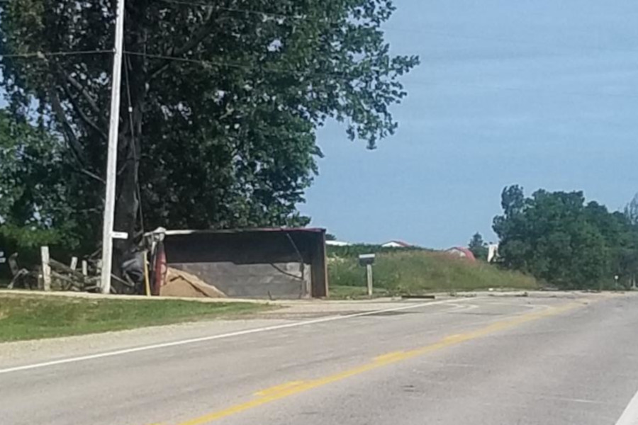 The dump truck landed on its side in a ditch.