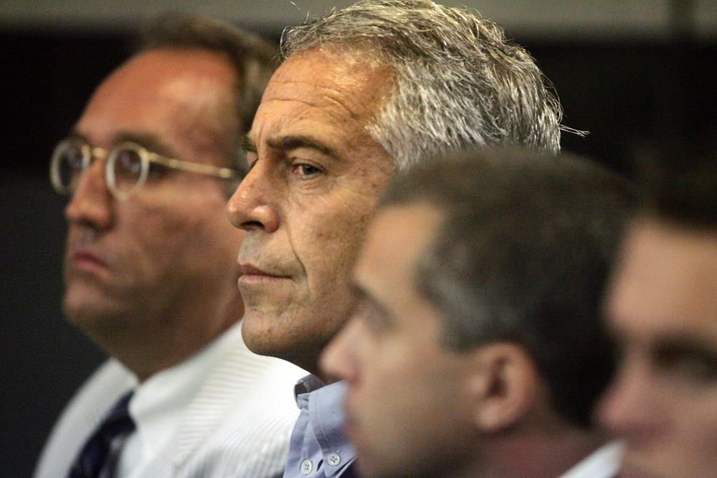 FILE - In this July 30, 2008 file photo, Jeffrey Epstein, center, appears in court in West Palm Beach, Fla. The wealthy financier and convicted sex offender has been arrested in New York on sex trafficking charges. Two law enforcement officials said Epstein was taken into federal custody Saturday, July 6, 2019, on charges involving sex-trafficking allegations that date to the 2000s.