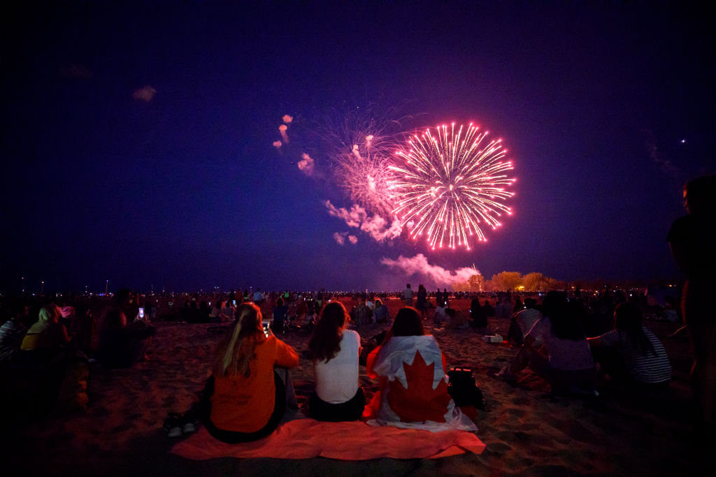 TORONTO, ON - JULY 01: People watch  fireworks fly over Ashbridges Bay during Canada Day festivities, on July 1, 2019 in Toronto, Canada. Canada Day commemorates the July 1, 1867 formation of Canada from three distinct colonies. 
