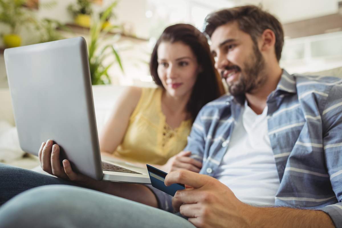 A happy couple shopping online because of the strong Canadian dollar