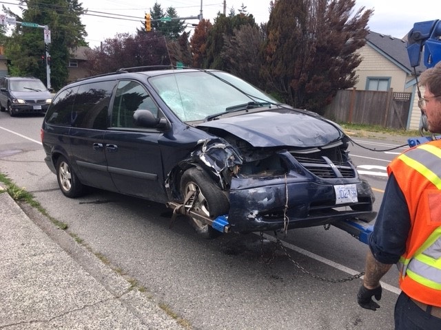 A smashed Dodge Caravan is towed away from the scene of a hit-and-run in Saanich on Monday. 